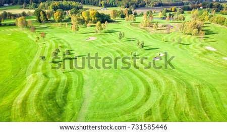 Similar – A tranquil aerial view of a lush golf course fairway, bathed in the warm glow of sunset. Ideal for themes of relaxation, nature, and sports, this image captures the peaceful beauty of the golfing experience.