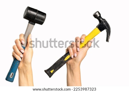 Different hammers in a woman's hand on a white background. A tool with signs of wear in a woman's hand.