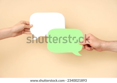 Different hands with speech bubbles on beige background
