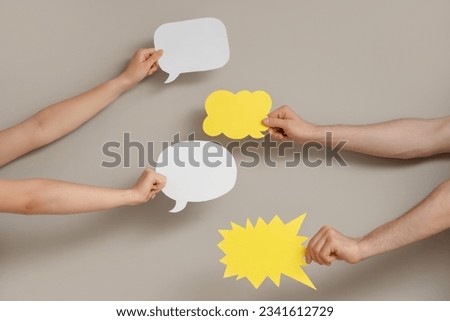Different hands with speech bubbles on grey background