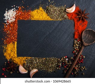 Different kind of spices on a black stone background - Shutterstock ID 1069428665