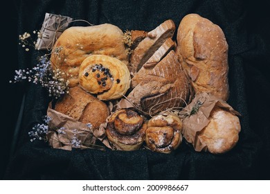 Different Kinds Of Bread And Baked Goods, Placed Into Box In Vintage Style Decorated With Dry Flowers.