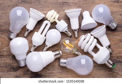 Different Kinds Of Light Bulbs On Wooden Background	