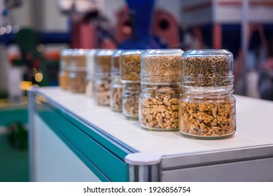 Different Kinds Of Pelleted Compound Feed, Fodder In Glass Jars: Before And After Extrusion - Food For Domestic Animals At Agricultural Exhibition, Trade Show: Close Up. Agriculture, Husbandry Concept