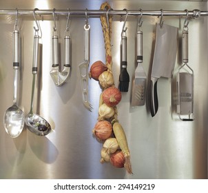 Different Kitchen Tools For Cooking (kitchenware) Hanging On The Wall