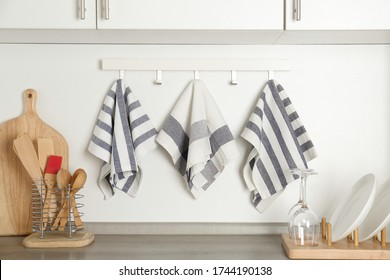 Different Kitchen Towels Hanging On Hook Rack Indoors