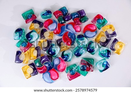 Different laundry detergent capsules on white background, top view