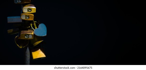 Different Love Locks In Yellow And Blue Colors Are Attached To A Vertical Iron Bar And Right Next To It A Lot Of Black Background