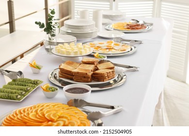 Different Meals For Breakfast On White Table Indoors. Buffet Service