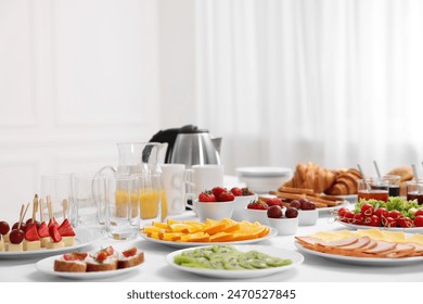 Different meals served on white table indoors. Buffet menu
