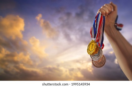 different medals in the blue sky in the sun in hand - Victory Concept - Powered by Shutterstock