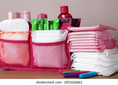 Different Menstrual Pads, Tampons And Skin Care Products On Wooden Table, Closeup