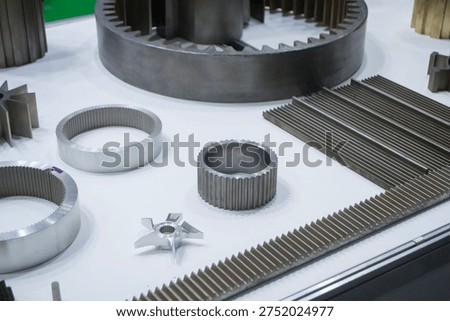 Different metal models on a white surface. Many metal products close-up. Various metal parts of gear transmissions. Gear wheels. Metal processing. Industrial metalworking objects. Steel manufacturing