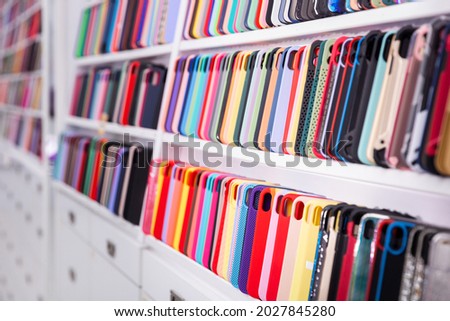 Different mobile phone cases on shelves in a multimedia store