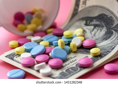 Different Multicolored Pills on One Hundred Dollar Bills. Concept Of Costs on Health Promotion And Medical Treatment. Vitamins Tablets And Pharmaceuticals. Expensive Healthcare Industry