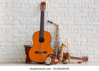 Different musical instruments near white brick wall - Powered by Shutterstock