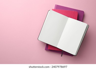 Different notebooks on light pink background, top view. Space for text - Powered by Shutterstock