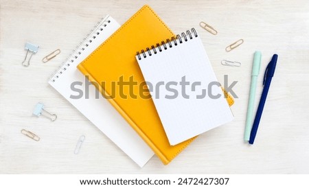Different notebooks on table top view. Empty notepad with place for message. Bright flatlay stationery.