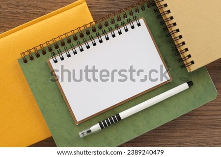 different notebooks and page. Blank notepad page for entering text in the middle. Top view, flat lay.