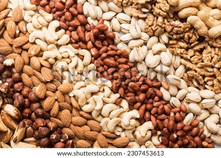 different nuts background. Close up, top view, flat lay. Walnut, pistachios, almonds, hazelnuts and cashews