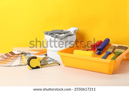 Different painter's tools on white wooden table. Decorating and design