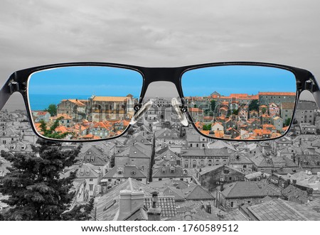 Different perception of world. Colorful view of red roods and blue sea in  the glasses. Looking through glasses. 