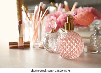 Different perfume bottles on dressing table, space for text