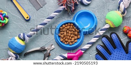 Different pet accessories and food on grey background, top view