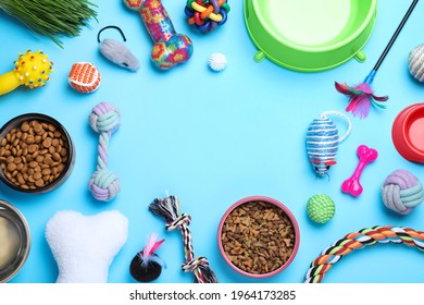 Different Pet Toys And Feeding Bowls On Light Blue Background, Flat Lay. Space For Text