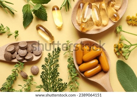Different pills and herbs on pale orange background, flat lay. Dietary supplements