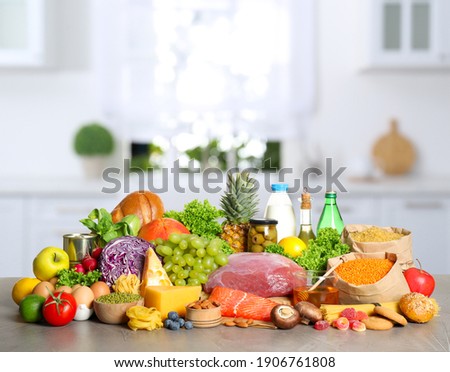 Different products on wooden table in kitchen. Healthy food and balanced diet