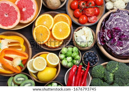 Different products rich in vitamin C on wooden table, flat lay