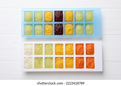 Different Purees In Ice Cube Trays On White Wooden Table, Flat Lay. Ready For Freezing