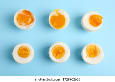 Different readiness stages of boiled chicken eggs on light blue background, flat lay - Powered by Shutterstock