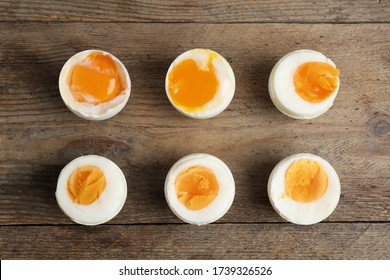 Different readiness stages of boiled chicken eggs on wooden table, flat lay - Powered by Shutterstock