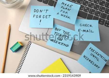 Different reminder notes and laptop on white table, flat lay