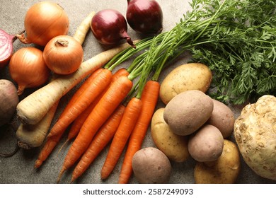 Different root vegetables on grey table, flat lay