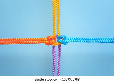 Verschiedene Seile verbunden mit Knoten auf Farbhintergrund. Einheitskonzept