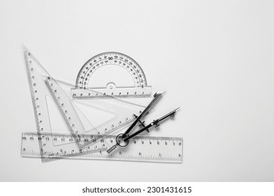 Different rulers and compass on white background, top view