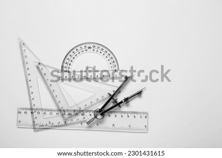 Different rulers and compass on white background, top view