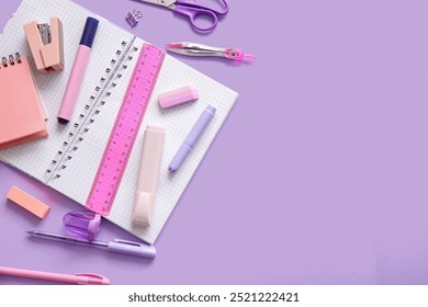 Different school stationery and notebook on purple background