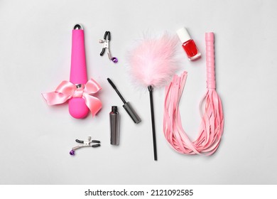 Different sex toys and cosmetics on light background