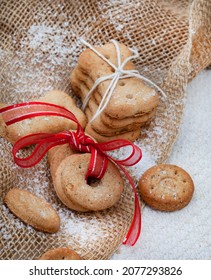 Different Shapes Of Dog Treat Biscuits On Light And Neutral Tabletop With Christmas Ornaments