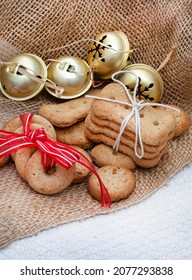 Different Shapes Of Dog Treat Biscuits On Light And Neutral Tabletop With Christmas Ornaments