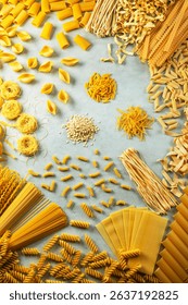 Different shapes of pasta are creating a frame on a gray background, showcasing italian culinary tradition
