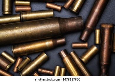 Different Size Bullet Shells On The Black Ground. War Concept. 