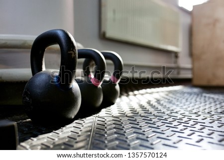 Different sizes of kettlebells weights lying on gym floor. Equipment commonly used for crossfit training at fitness club