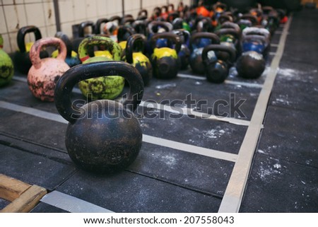 Different sizes of kettlebells weights lying on gym floor. Equipment commonly used for crossfit training at fitness club