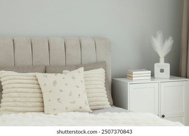 Different soft pillows on bed in room - Powered by Shutterstock