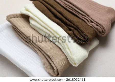 Different soft socks on light beige background, closeup